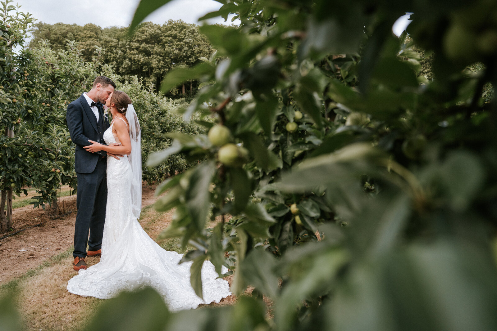A couple in the apple orchards at The BarnYard on their wedding day