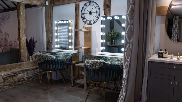 Lit vanity mirrors and velvet stools in the bridal suite