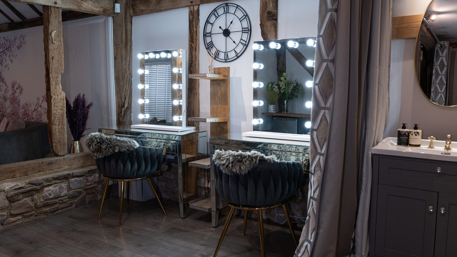 Lit vanity mirrors and velvet stools in the bridal suite
