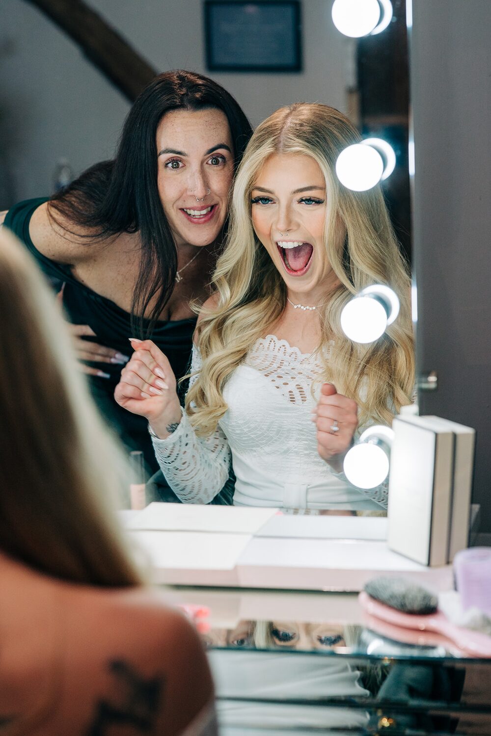 Bridesmaids cheering the bride at the mirror
