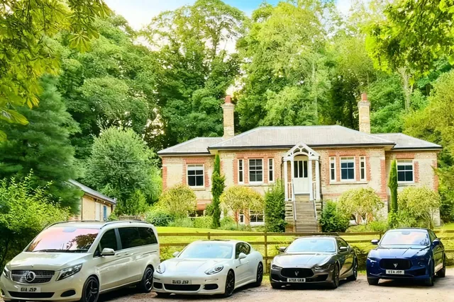 The chauffeur fleet lined up outside a country house: a cream Mercedes V-Class, a white Porsche Panamera and two Maseratis