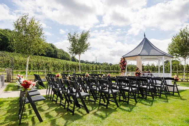 The Orchard Garden gazebo dressed with autumn florals, chairs set out on the lawn