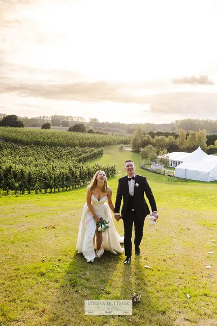 A couple walking the field path with the Arboretum behind