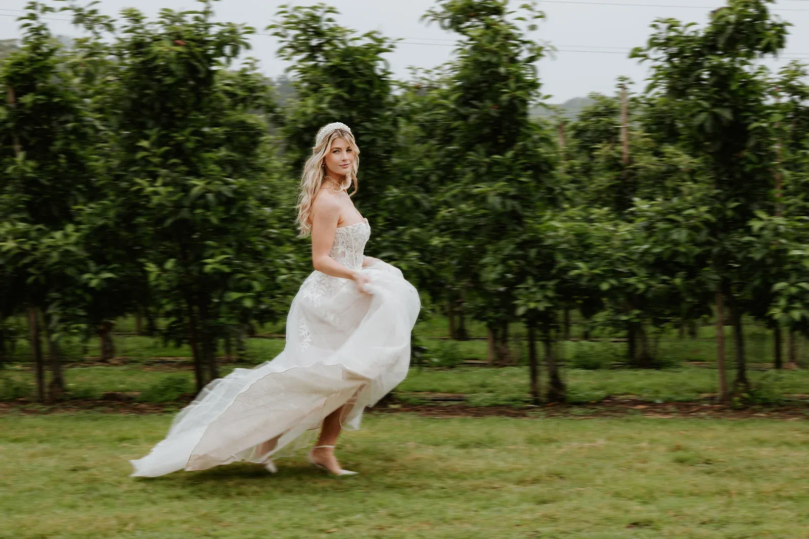 A bride walking through the orchard at The BarnYard