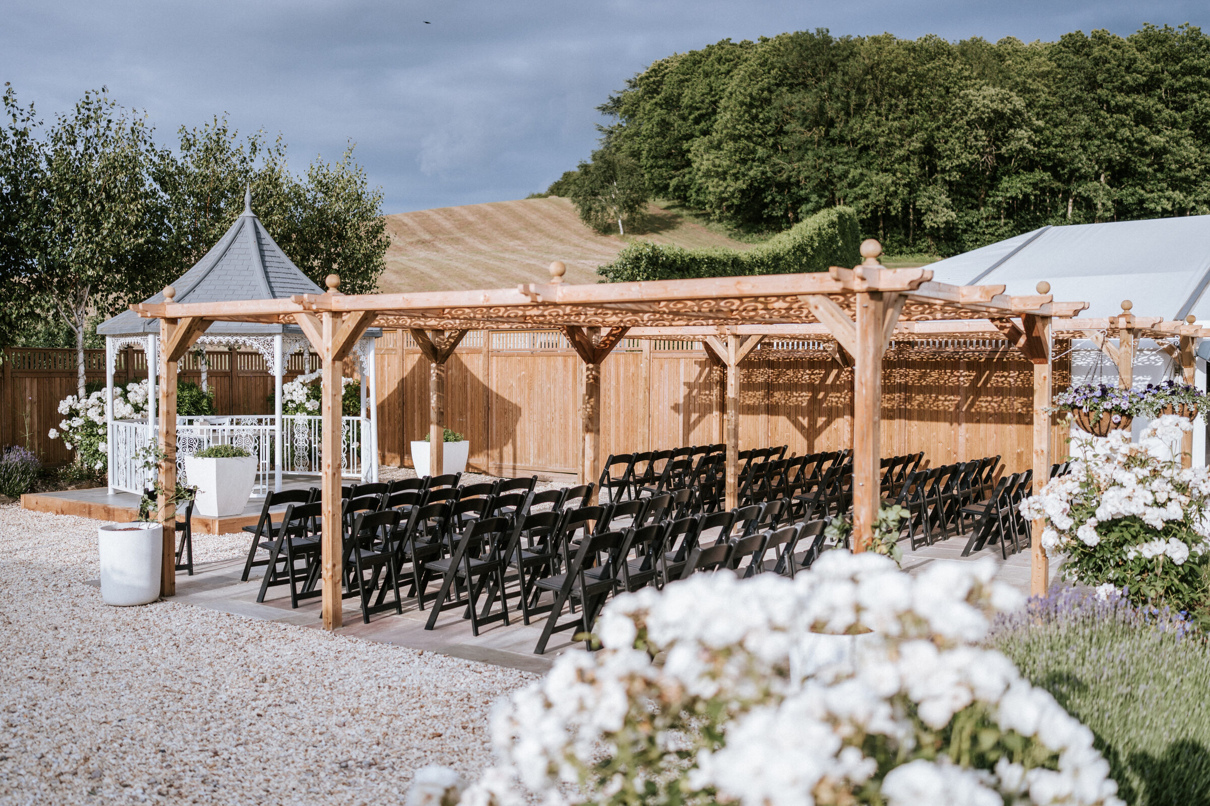 The Lavender Walk ceremony seating at The BarnYard beneath the new wooden shade gazebo, the white gazebo at the head of the aisle