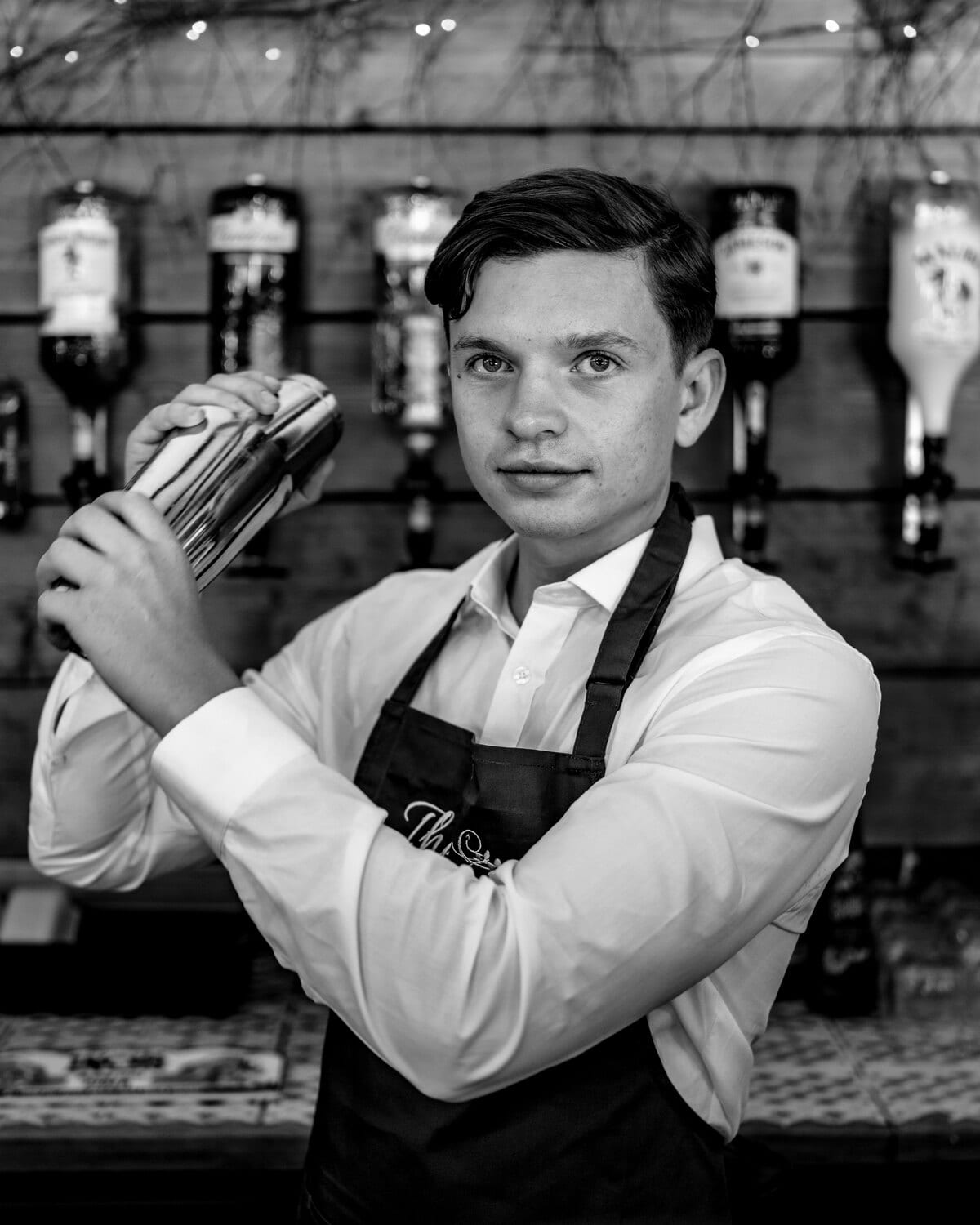 A BarnYard bartender shaking a cocktail behind the bar