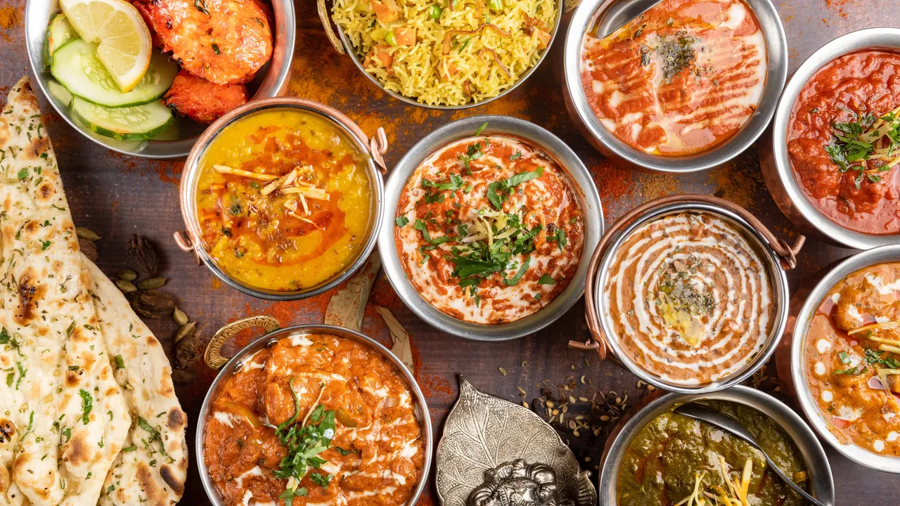 An Indian wedding spread of curries, dal, rice and naan in copper serving bowls