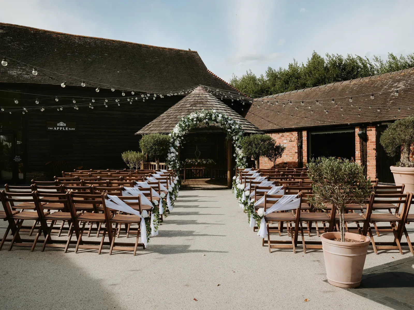 The Courtyard outside the Apple Barn at The BarnYard, set for a Twilight wedding ceremony beneath the festoon lights