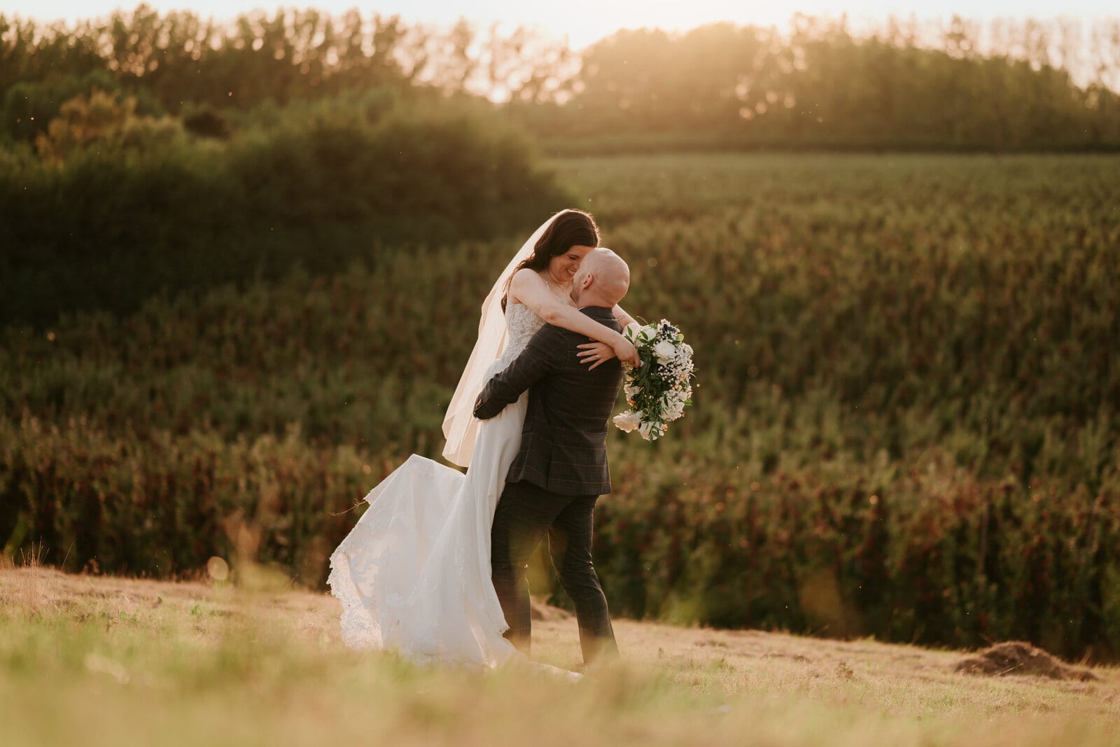 A couple at golden hour in the orchards at The BarnYard